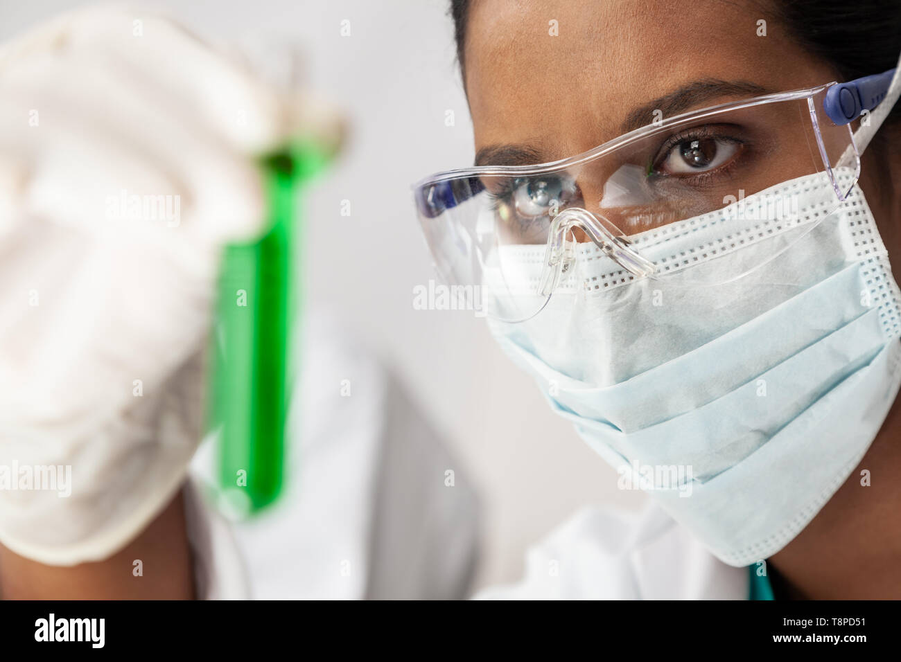 Asiatische Frau medizinische oder wissenschaftliche Forscher oder Arzt an einem Test Tube grüne Lösung in einem Labor oder Labor suchen Stockfoto