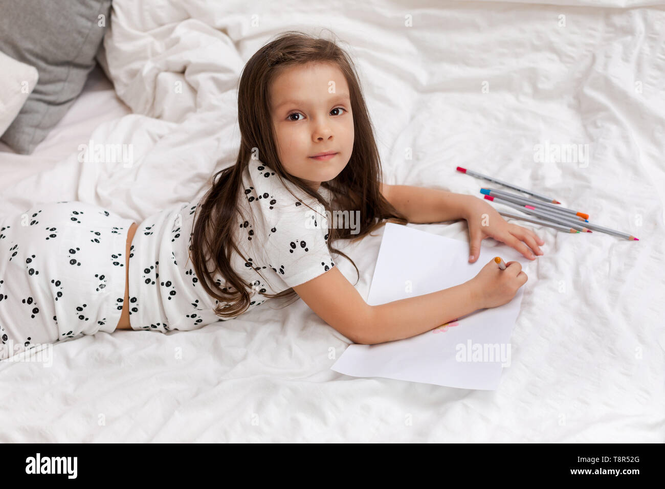 Süße kleine Mädchen Zeichnen von Bildern beim liegen auf dem Bett. Kind malen zu Hause Stockfoto