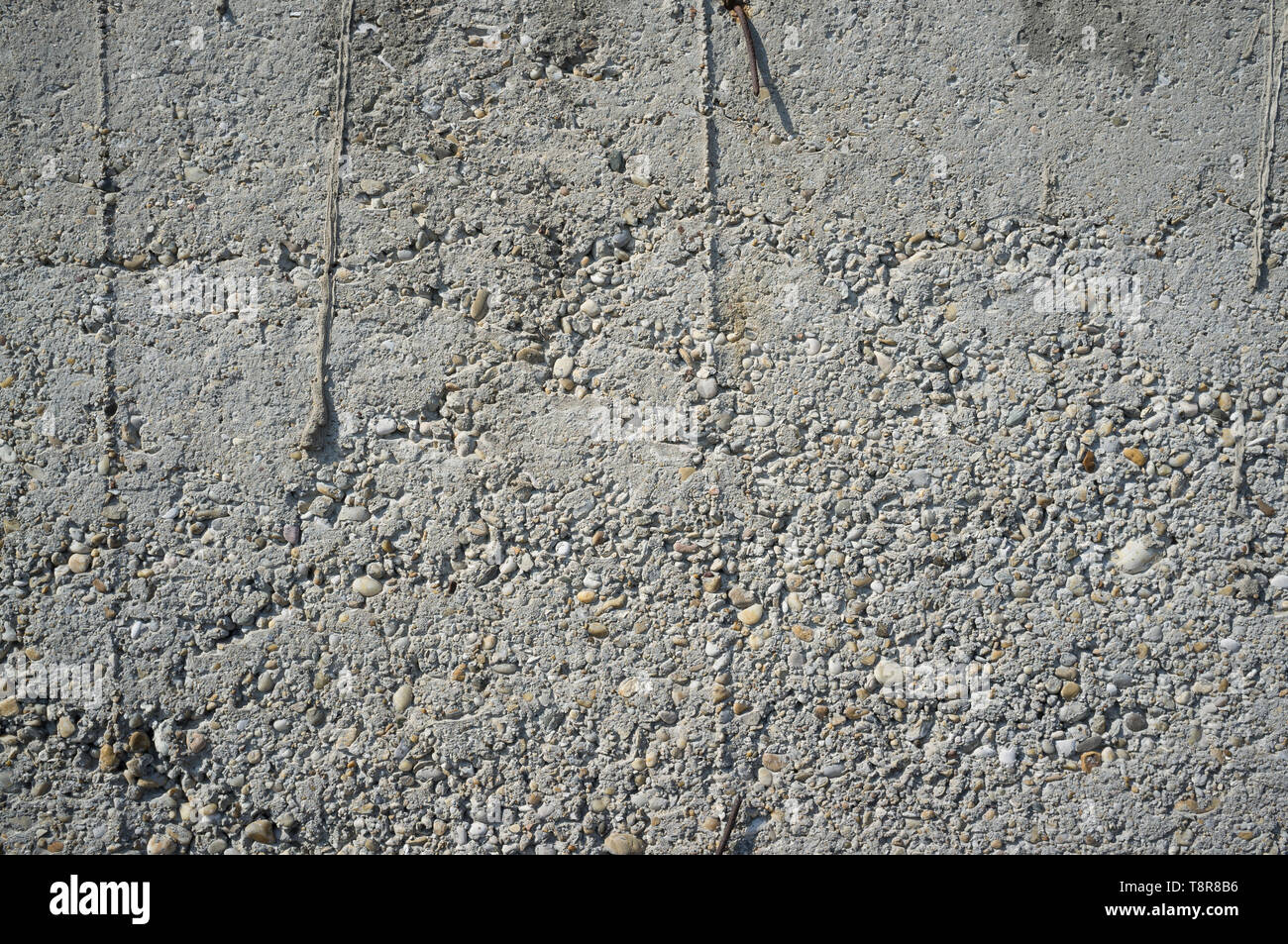 Krümelig etwa Getan verwitterten graue Betonwand mit Kieselsteinen Textur Detail Stockfoto