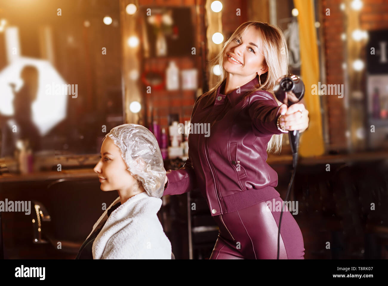 Freudige gerne professionelle kaukasischen Frauen Friseur in der Nähe von  Client, Haartrockner und Kamera mit Lächeln. Beauty Salon, Haare Auto  Stockfotografie - Alamy
