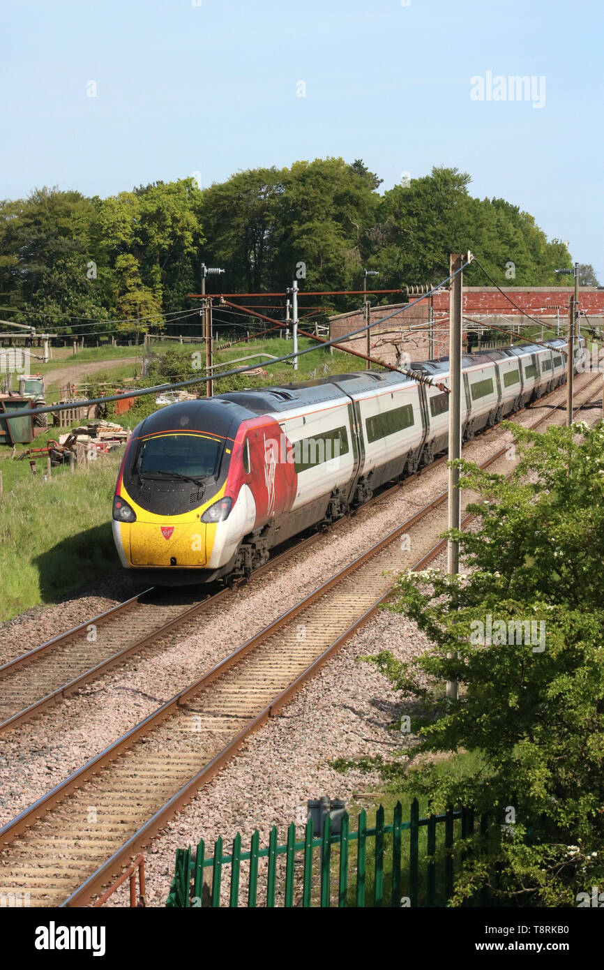 Jungfrau Westküste Pendolino wwu auf die West Coast Main Line, in der Nähe von Garstang Woodacre, Lancashire, England, Dienstag, 14. Mai 2019, London nach Edinburgh. Stockfoto