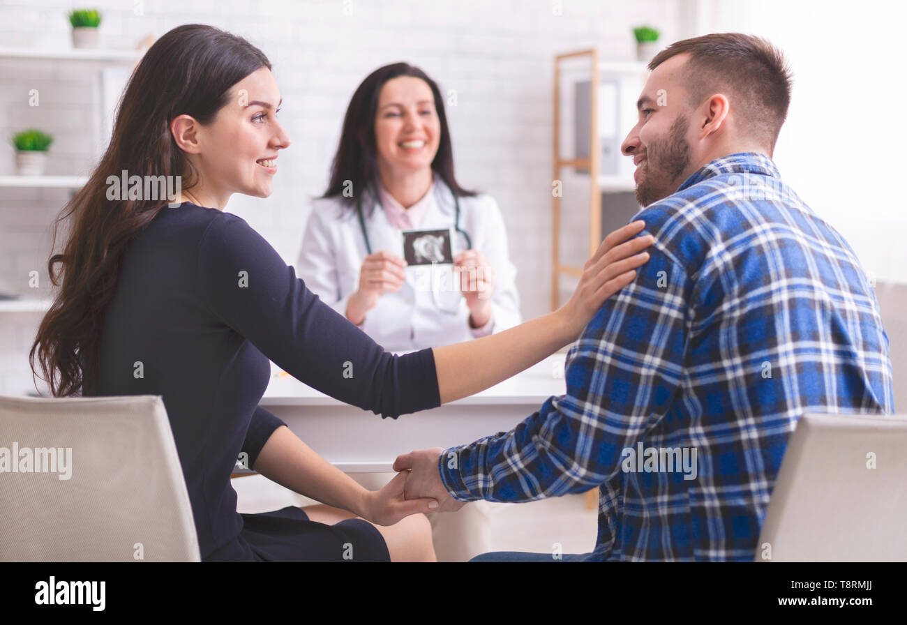 Arzt, Ultraschall Bild zu Jungen glückliches Paar Stockfoto