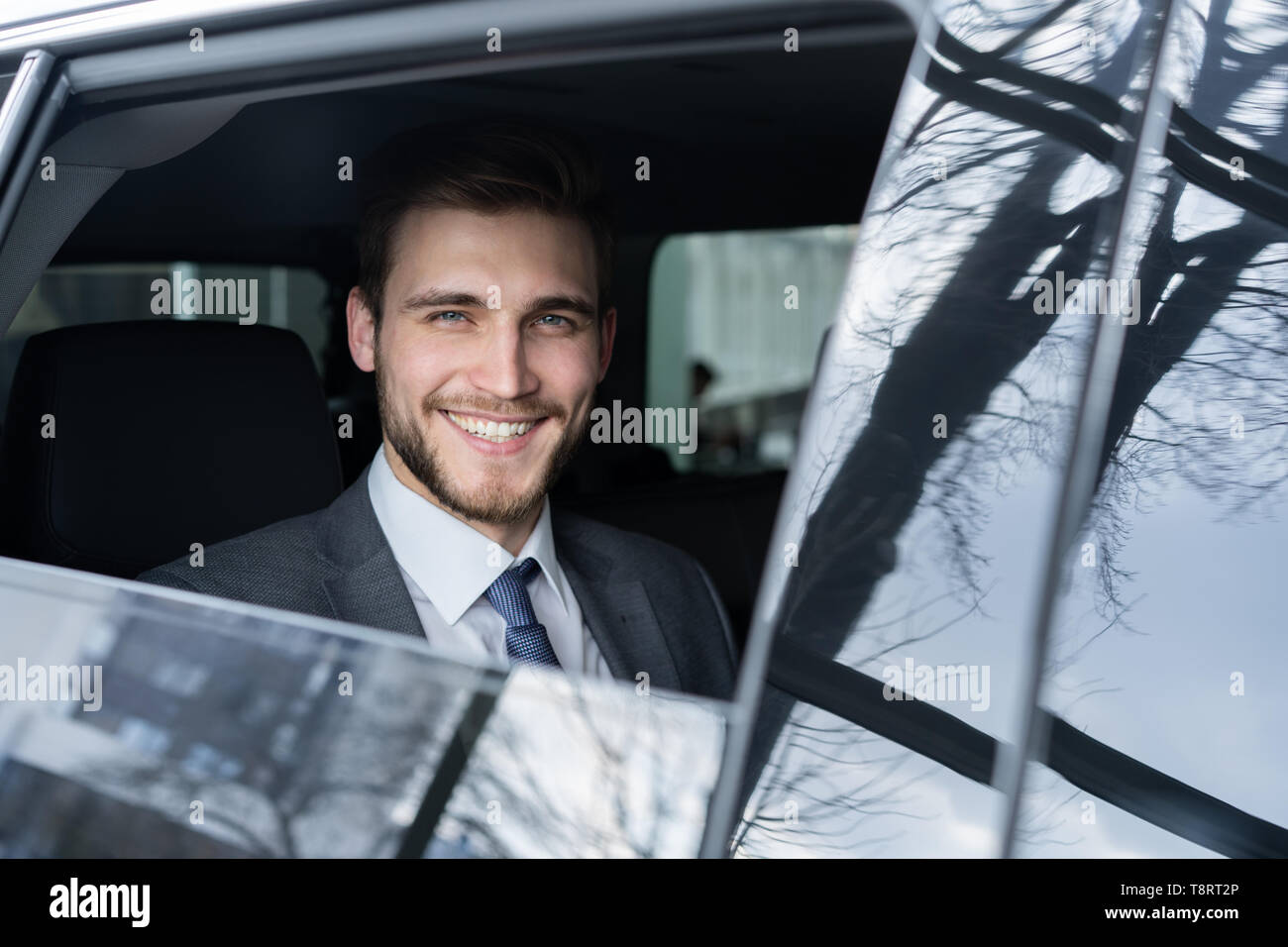 Junge gut aussehender Geschäftsmann sitzt in Luxury Car Stockfoto