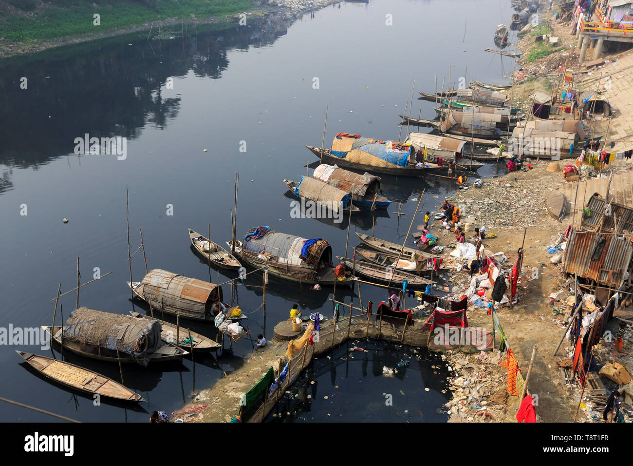 Gypsy Frauen und Mädchen, die auf Hausbooten leben, tun alle inländischen Reinigung in der Dunkelheit, verschmutztes Wasser des Flusses an Turag Tongi in Gazipur. Stockfoto