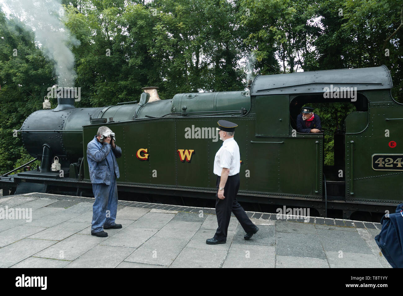 Station Master und Treiber neben GWR Klasse 2-8-0 T 4247 Zug am Bodmin Parkway Bahnhof Cornwall GROSSBRITANNIEN Stockfoto