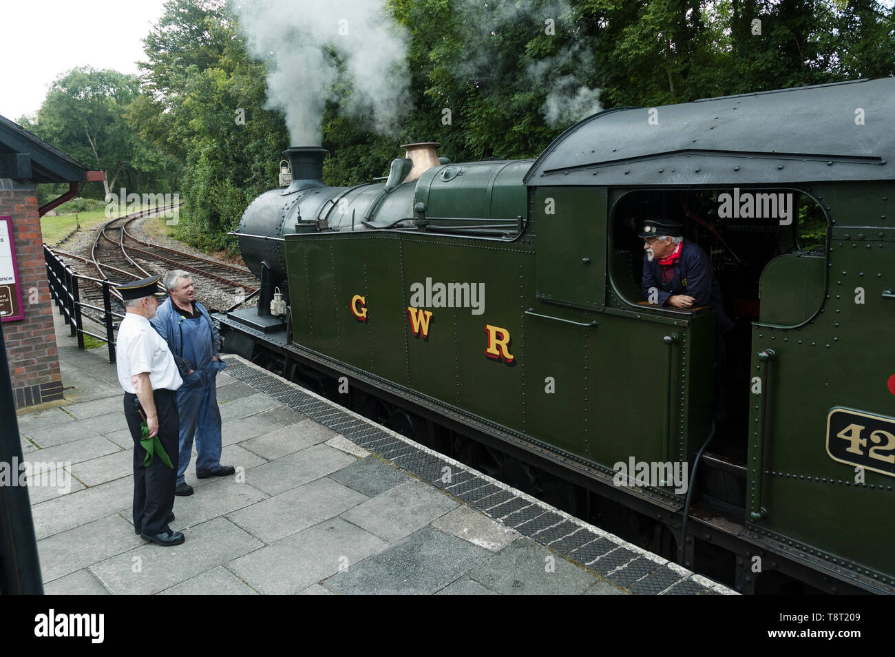 Station Master und Treiber neben GWR Klasse 2-8-0 T 4247 Zug am Bodmin Parkway Bahnhof Cornwall GROSSBRITANNIEN Stockfoto