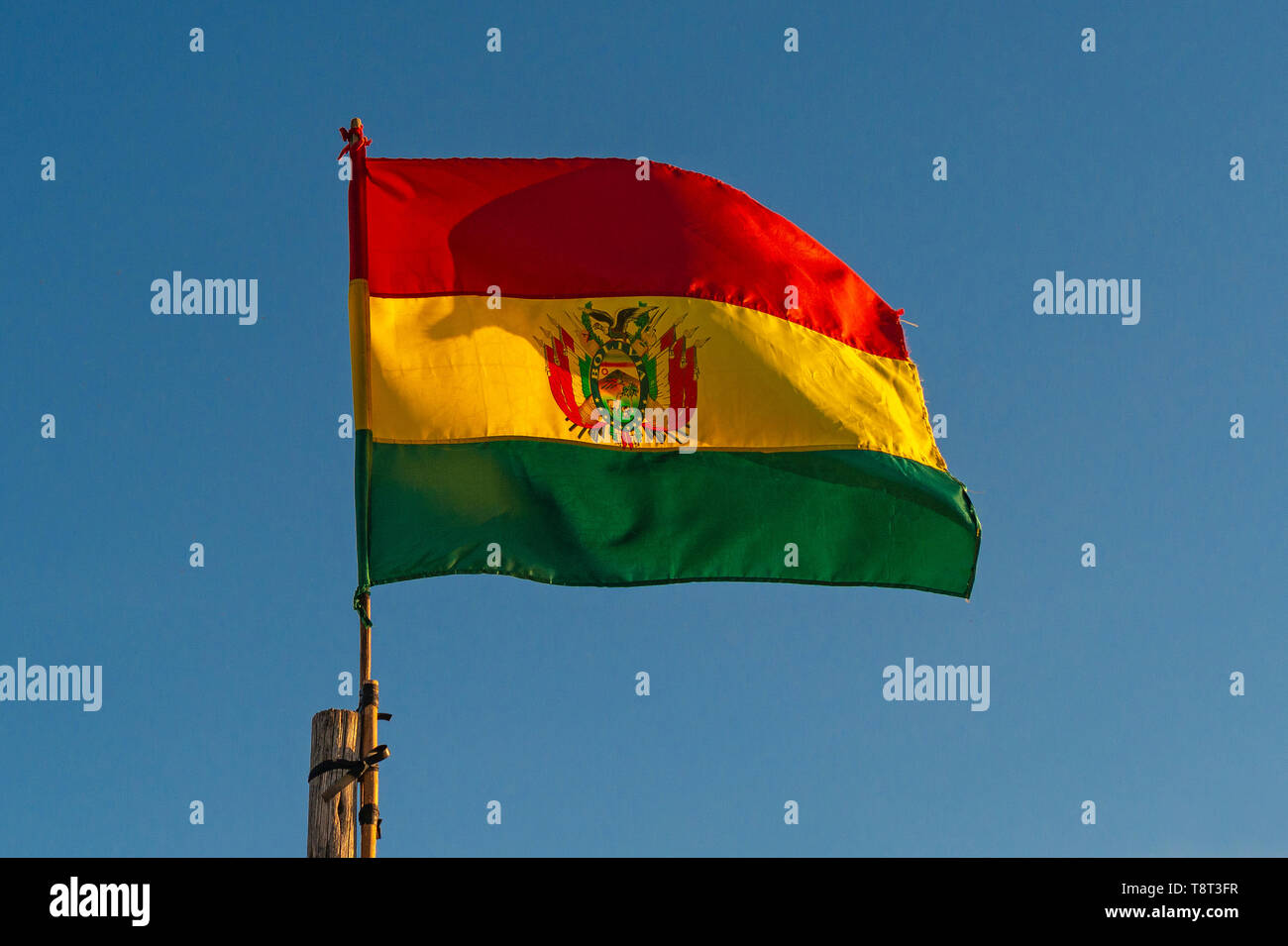 Die Fahne Boliviens mit blauen Himmel bei Sonnenuntergang, Symbol der Unabhängigkeit, Staat, Freiheit und Patriotismus. Stockfoto