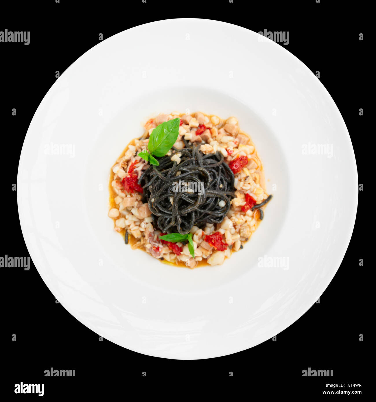 Schwarzes Tintenfisch Nudeln mit Meeresfrüchten in der Platte, isoliert auf Schwarz Stockfoto
