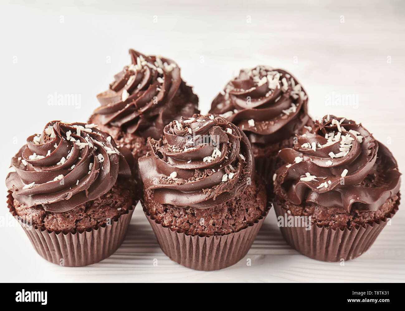 Leckere Schokolade Cupcakes auf weissem Holztisch Stockfoto