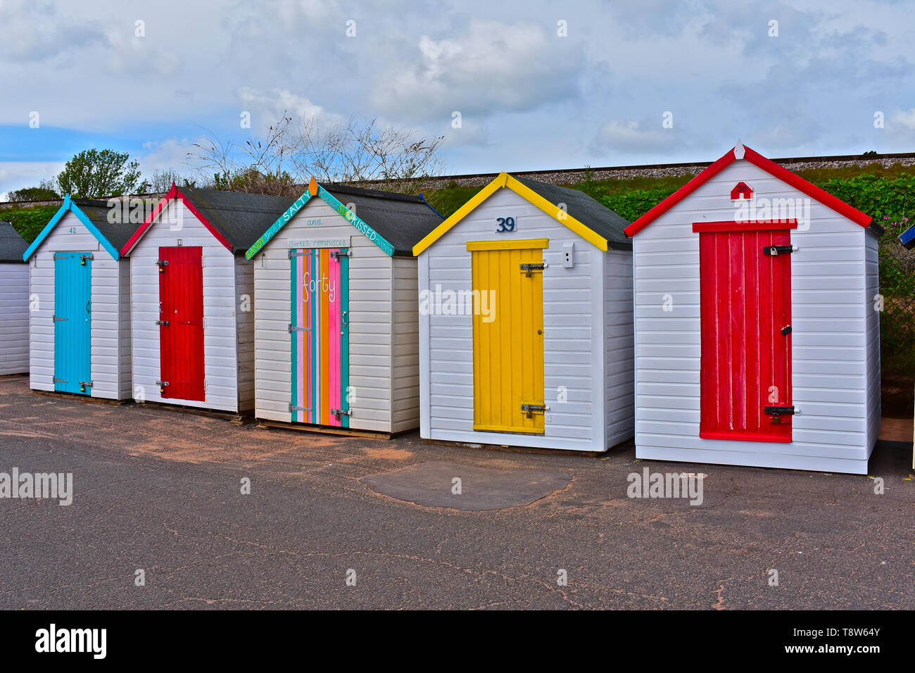 Eine bunte Reihe von bunten Badekabinen an der Strandpromenade mit Blick auf das Meer bei Goodrington Sands, in der Nähe von Paignton an der Englischen Riviera. Stockfoto