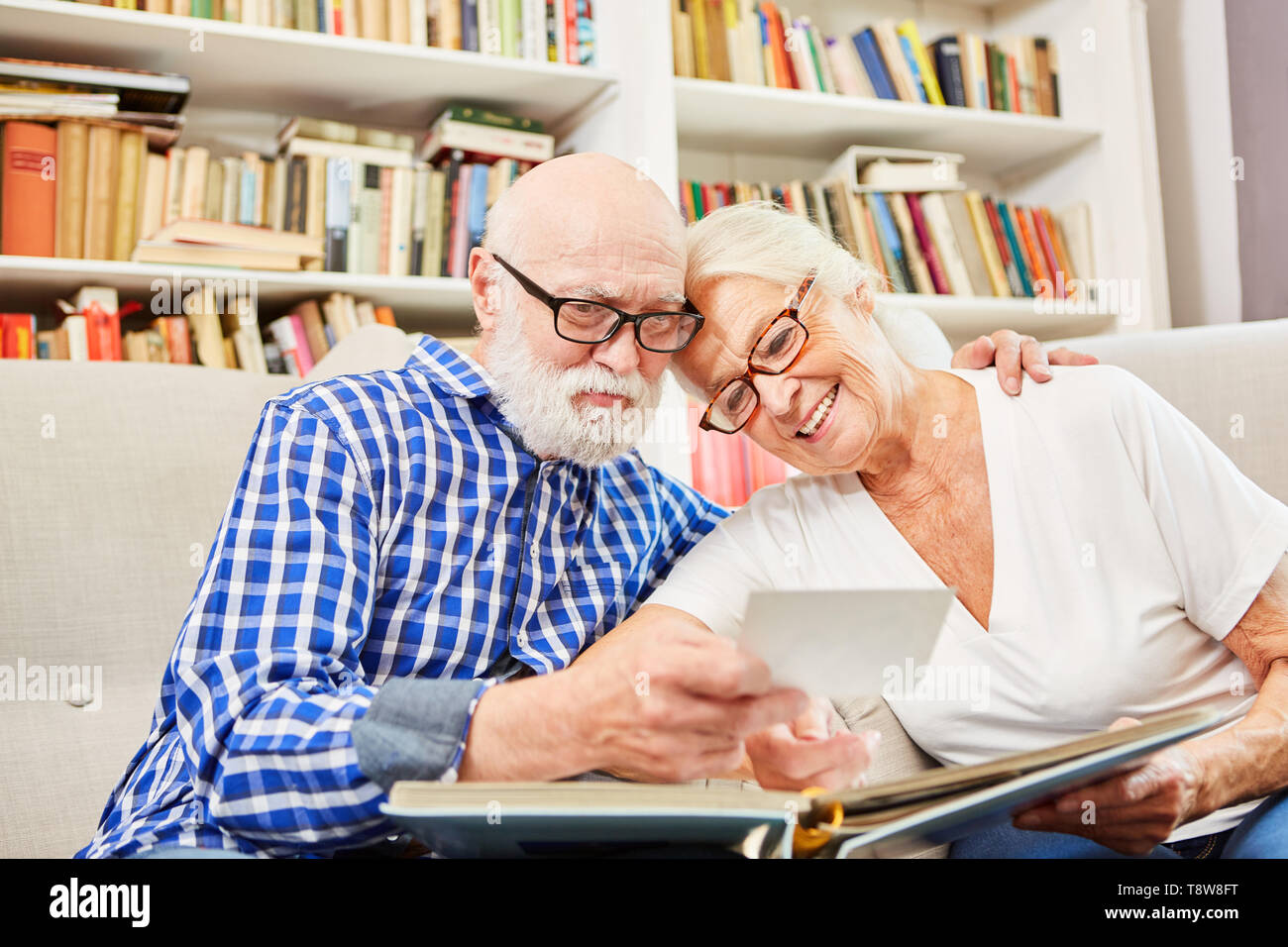 Glückliches Paar Senioren gemeinsam Betrachten von Fotos in der Senioren Residenz Stockfoto