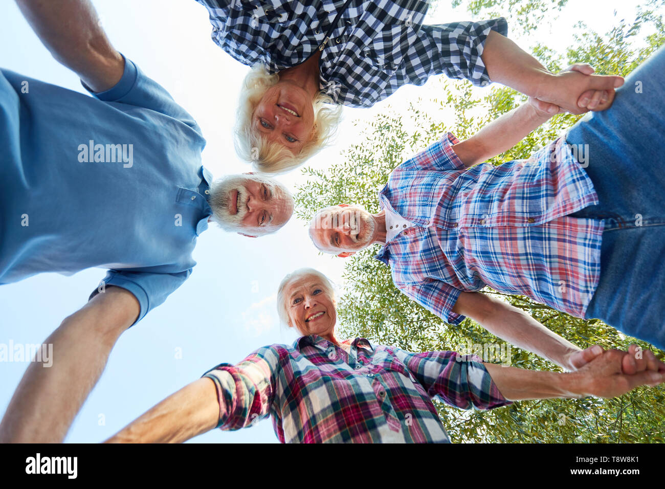Senioren bilden einen Kreis als Zeichen der Freundschaft und Gemeinschaft Stockfoto