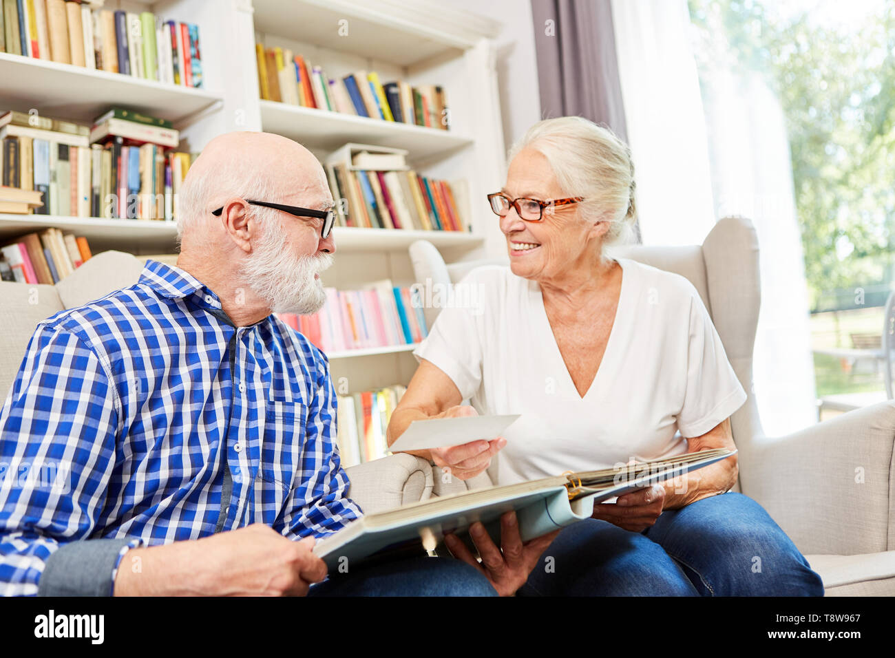 Happy Senioren Paar ist auf der Suche auf ein Foto Album in der Seniorenresidenz Stockfoto