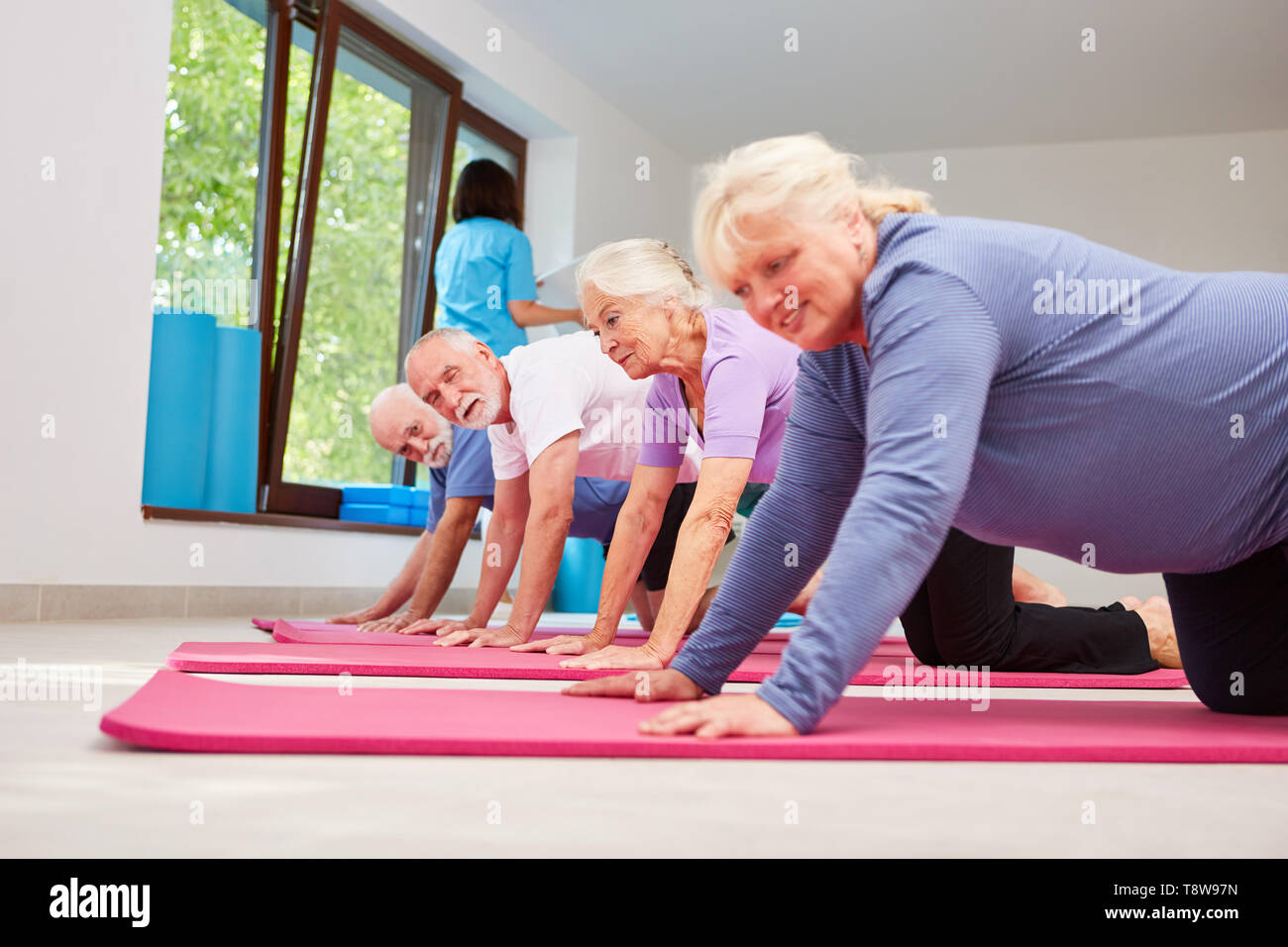 Aktive Senioren in der Klasse tun Push-ups auf der Yogamatte Stockfoto