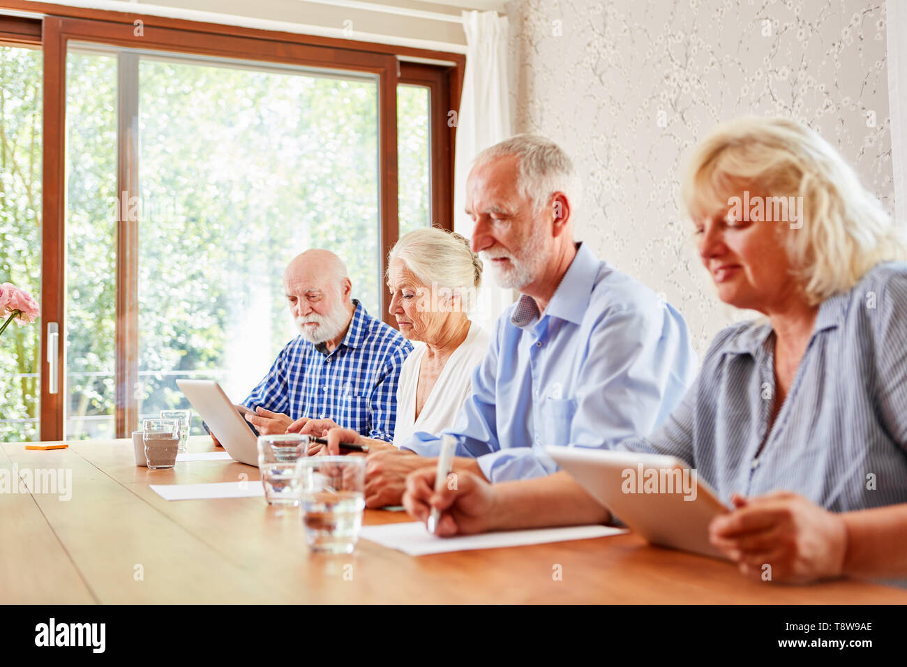 Senioren bilden zusammen eine e-learning Computer Kurs im Seniorenheim Stockfoto