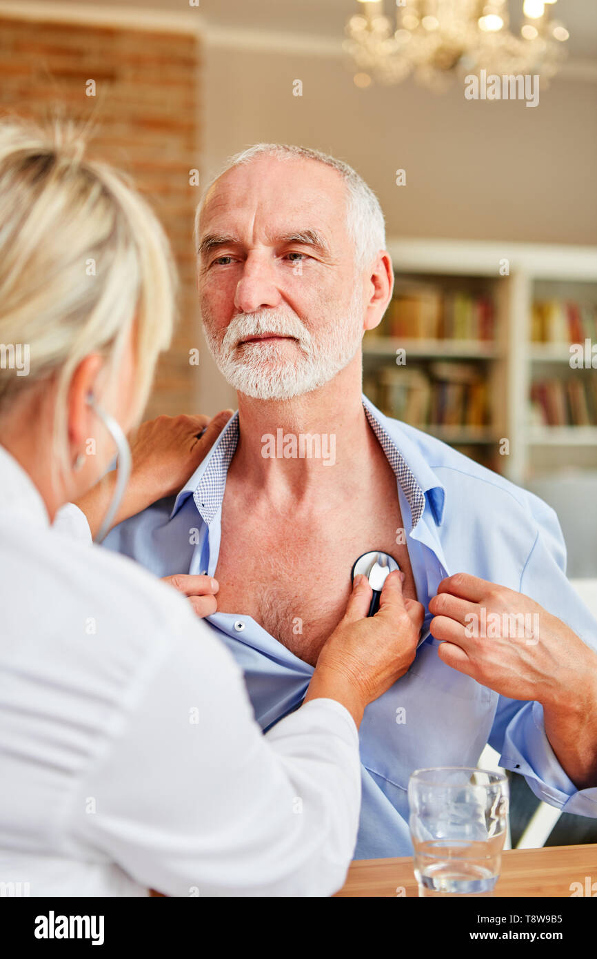 Ärztin und älterer Mann eine vorsorgliche Untersuchung mit dem Stethoskop Stockfoto