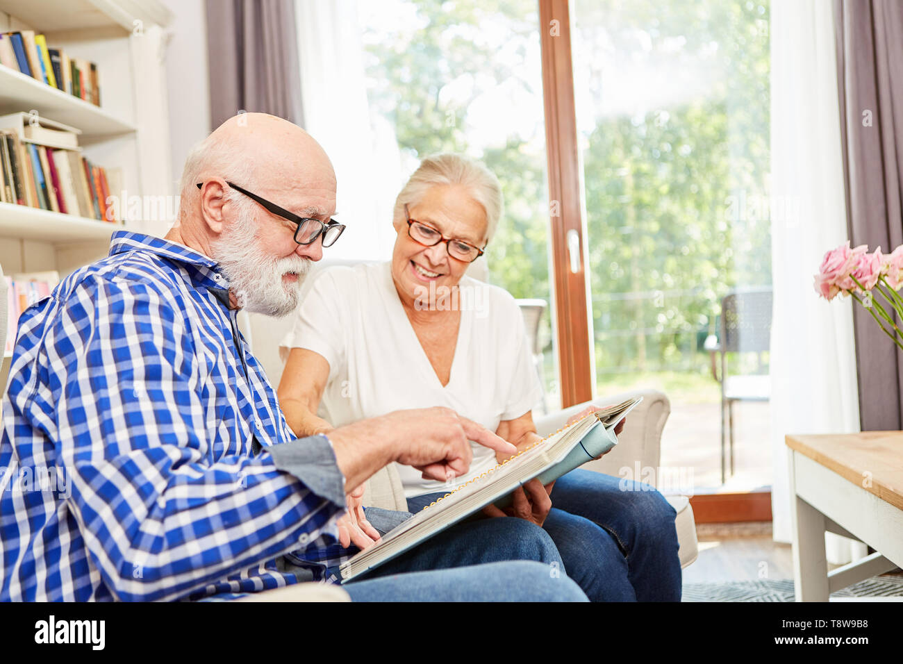 Paar Senioren mit Alzheimer bei Foto album in ihrem Ruhestand Home Suchen Stockfoto