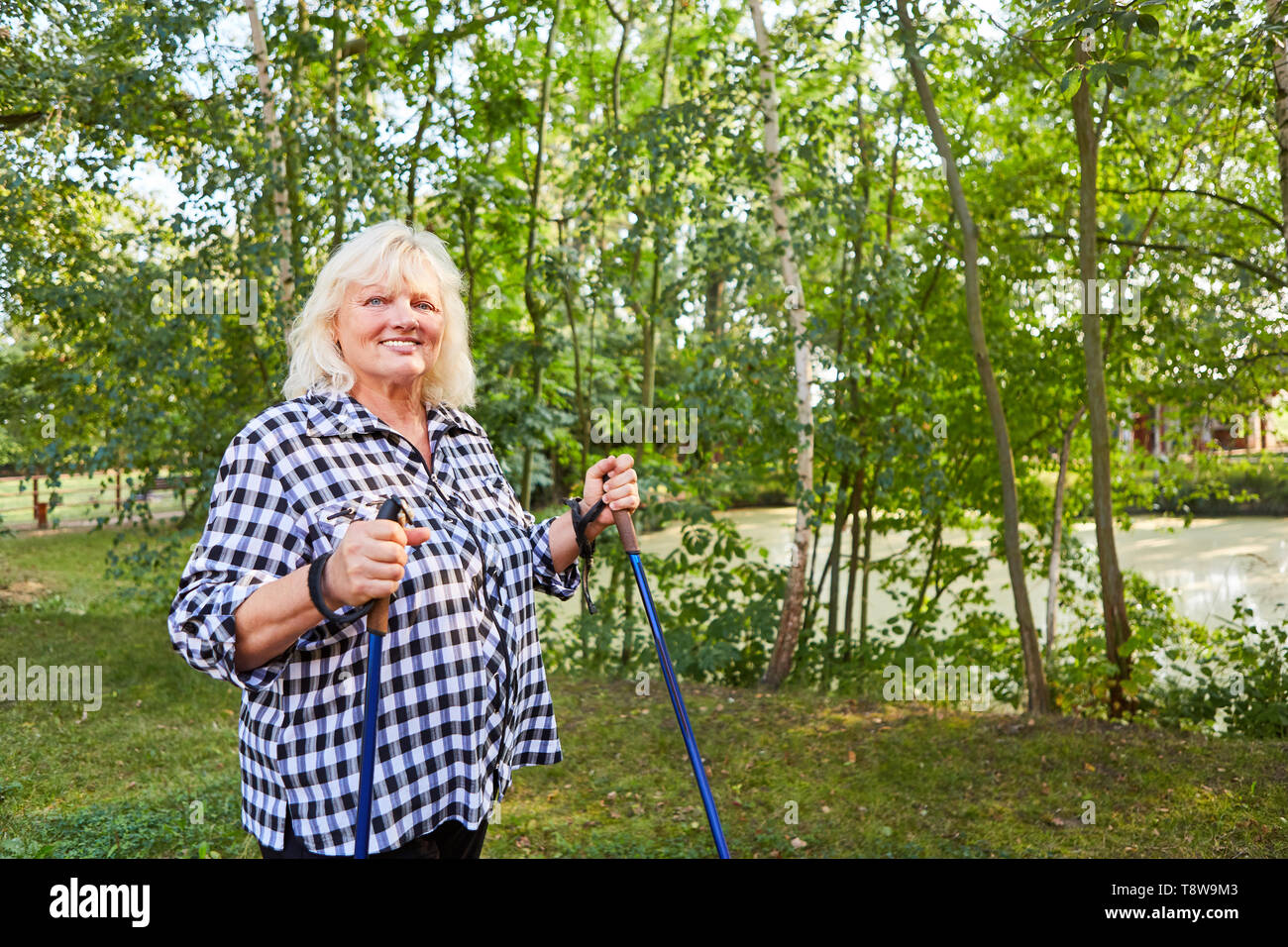 Ältere Frau mit Übergewicht Nordic Walkung für Gewichtsverlust Stockfoto