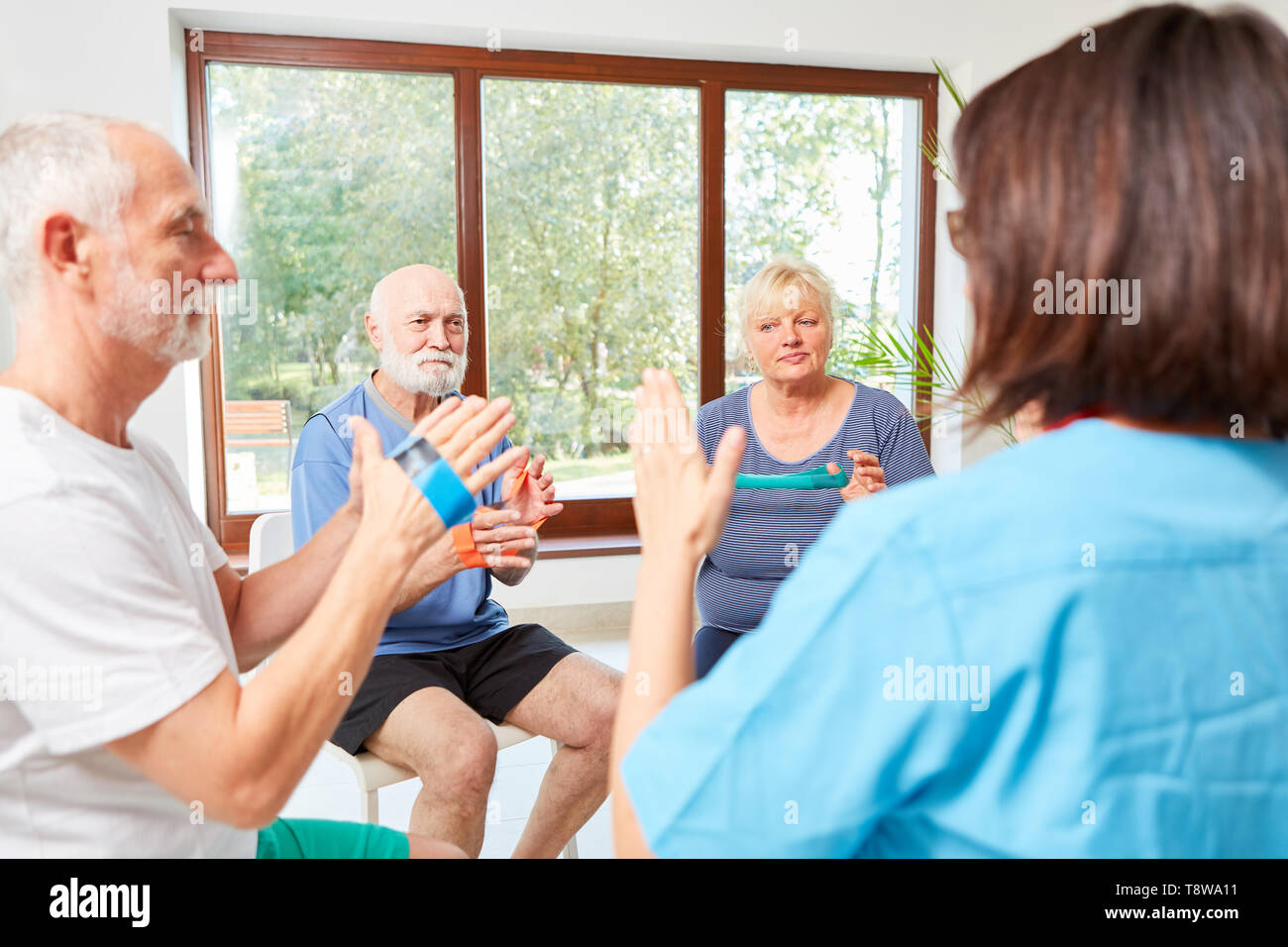 Gruppe von Senioren in rehab ist Übungen mit einem elastischen Band Stockfoto