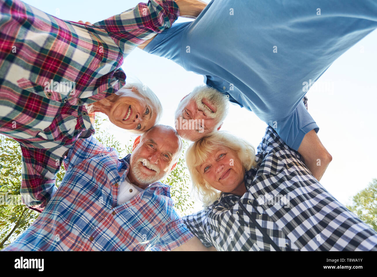 Senioren stehen zusammen in einem Kreis ein Konzept für Gemeinschaft und Stärke Stockfoto