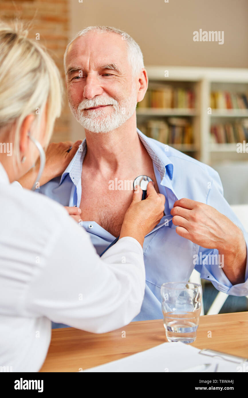 Ärztin untersucht, älterer Mann mit dem Stethoskop auf einem Home Besuch Stockfoto