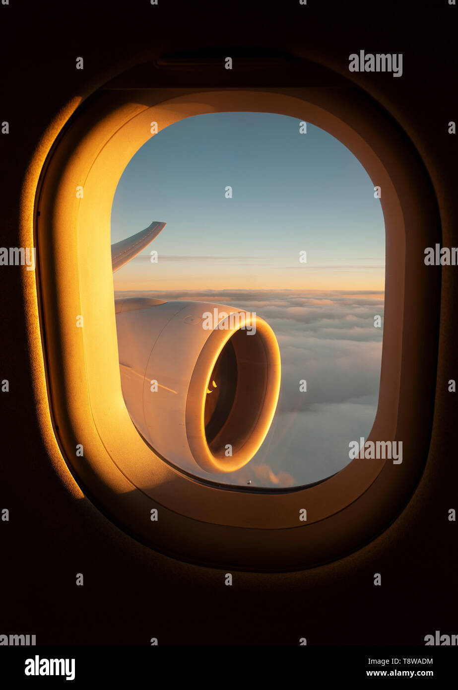 Blick aus dem Flugzeug Fenster des Jet-Flügel und den Motor während die Sonne untergeht Stockfoto