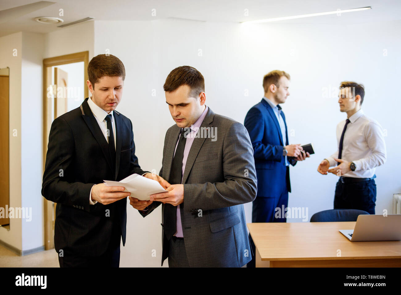 Geschäftsmann mit seinem Kollegen steht mit Dokumenten und es diskutieren. Stockfoto