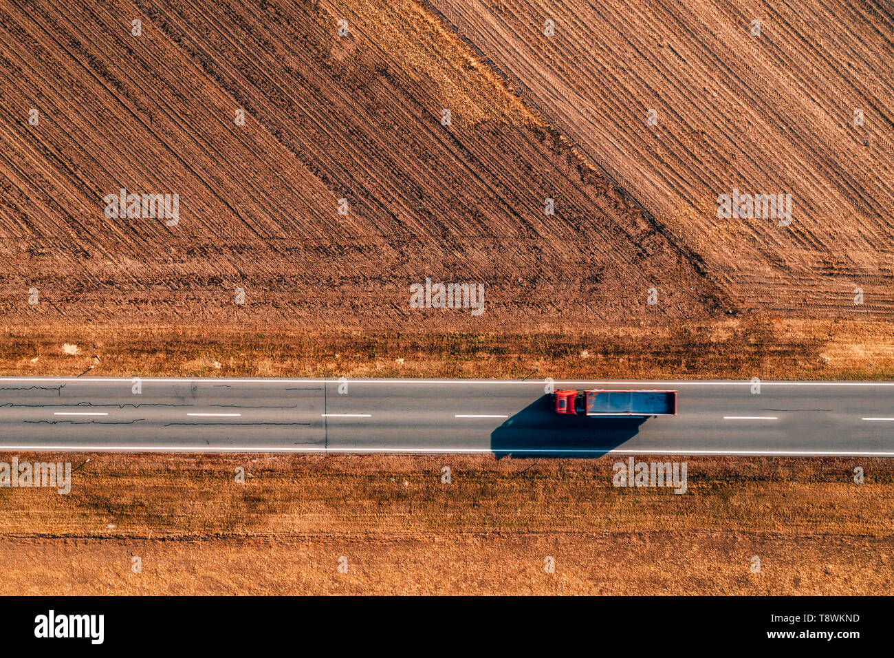 Luftaufnahme von Lkw auf der Straße durch die ebene Landschaft von Drone pov Stockfoto