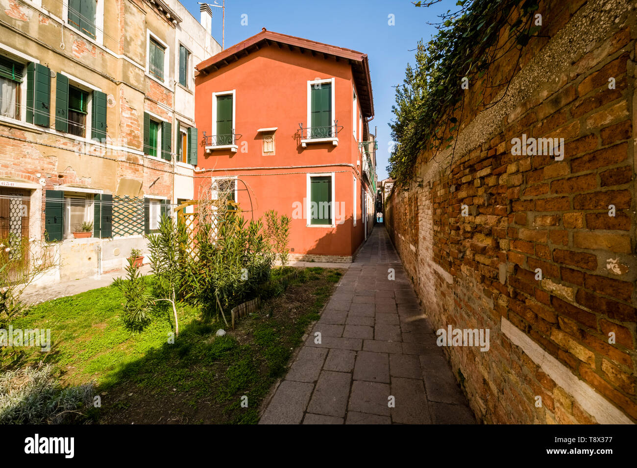 Hof einer terracotta Farbe lackiert Haus auf der Insel Giudecca, der von einer Steinmauer umgeben Stockfoto