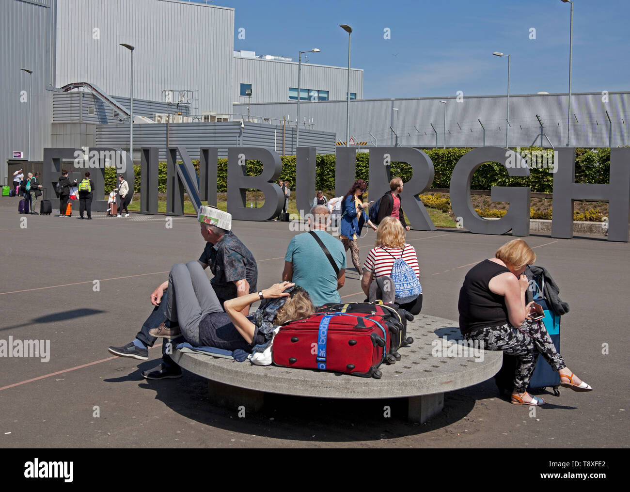 Edinburgh, Schottland. 15 Mai, 2019. UK Wetter. Mit Temperaturen von 20 Grad und keine Wolke am Himmel Bewohner und Touristen zu Spitze genießen das warme Wetter. Ein Mann am Flughafen Edinburgh Sport kreative Kopfbedeckung der Sonne fern zu halten, während er für einen Flug Arbeitern und wartet bis die Sonne im Westen die Princes Street Gardens genießen Sie von der Burg überragt. Credit: Bogen Weiß/Alamy leben Nachrichten Stockfoto