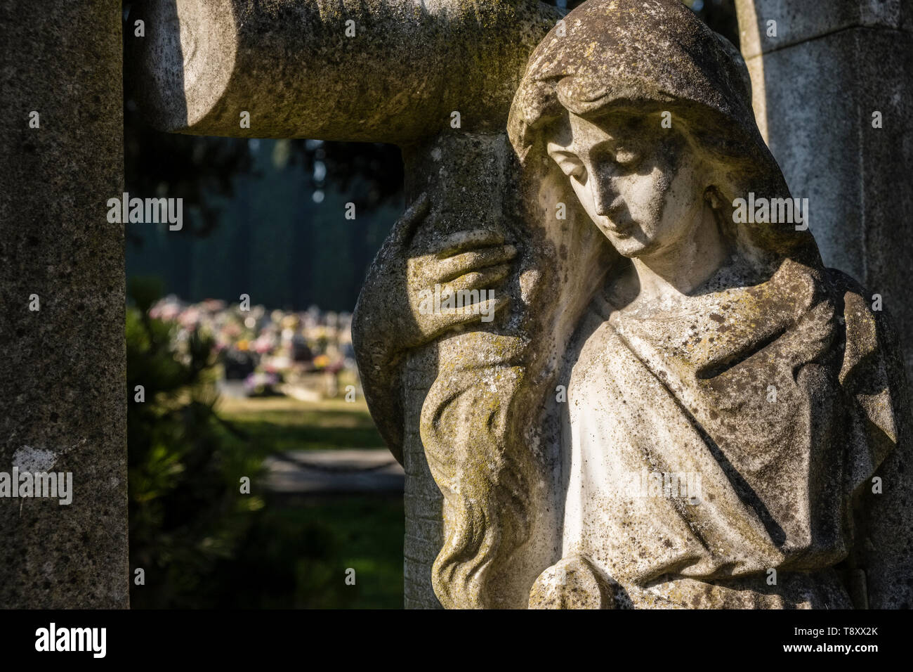 Die Felsen gehauene Skulptur eines weiblichen Trauernde mit Blick auf die Gräber auf dem Friedhof Insel Cimitero di San Michele Stockfoto