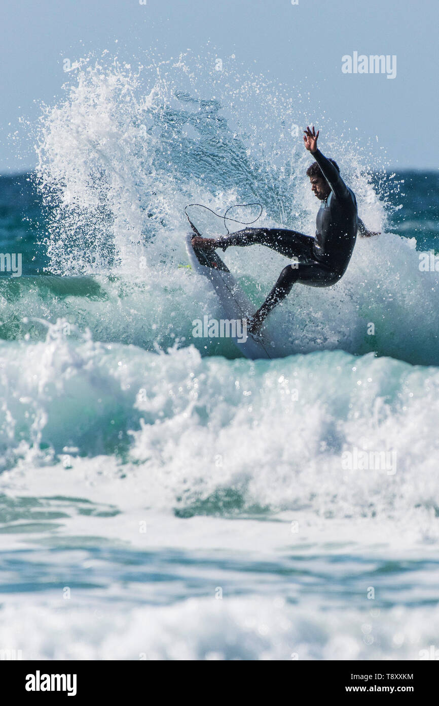 Dramatische surfen Aktion als Surfer führt eine Snap trick da reitet eine Welle im Jade farbigen Meer bei Fistral in Newquay in Cornwall. Stockfoto