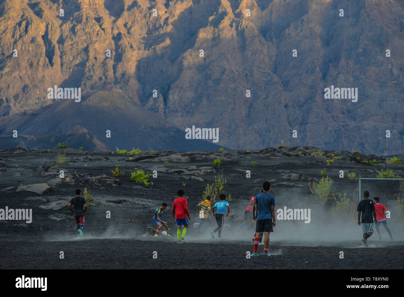 Kap Verde, Cabo Verde Archipel, Insel Fogo: Landschaft der "Cha das caldeiras "Caldera mit Jugendlichen Fußball auf einem Feld in abgedeckt Stockfoto