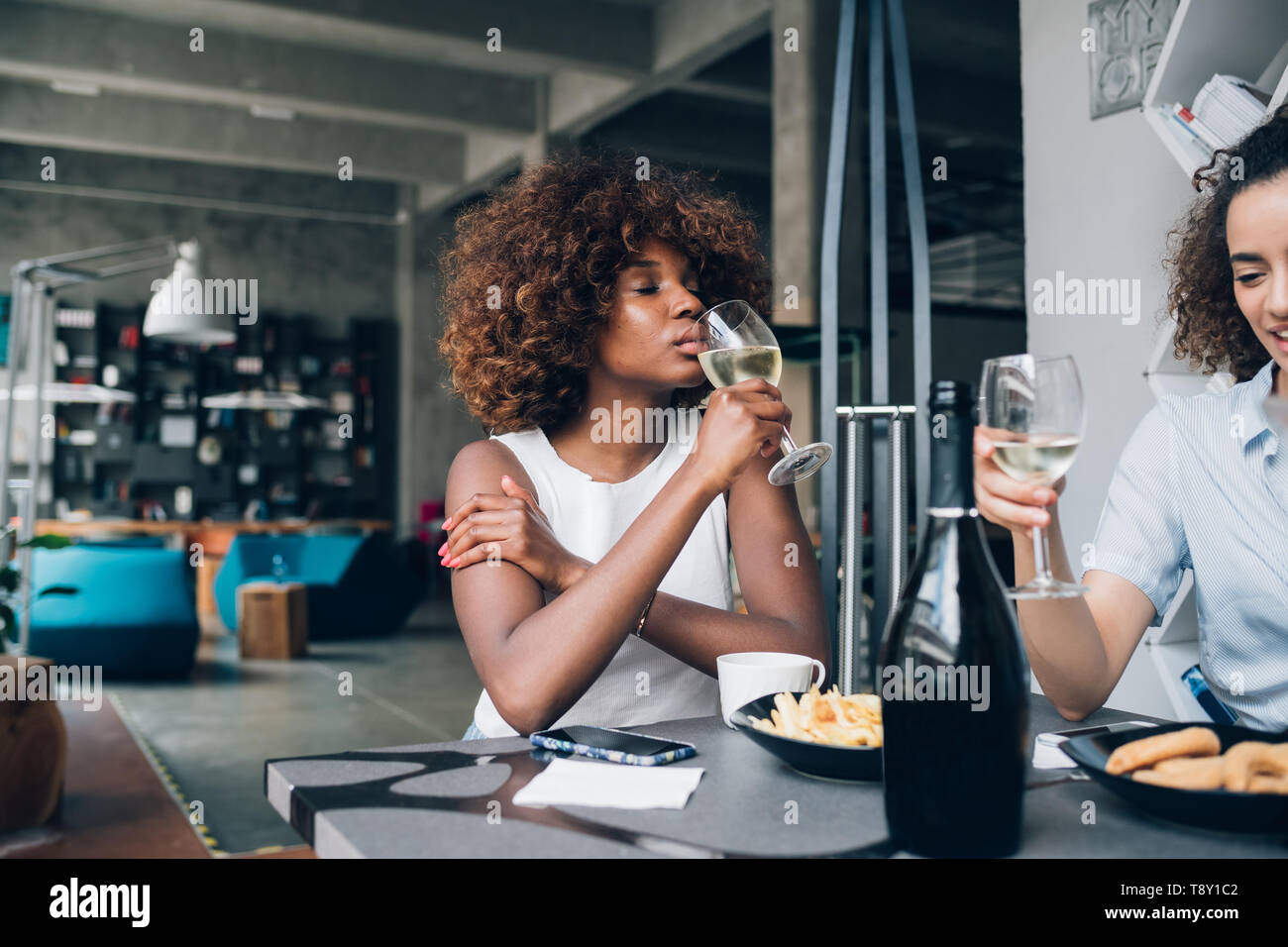 Zwei junge Mädchen trinken und Sitzen in der Bar - Freundschaft, entspannend, Interaktion Stockfoto