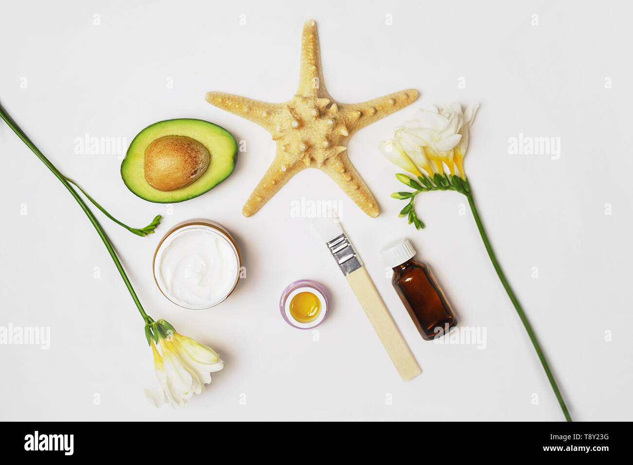 Schönheit Konzept Avocado, Hautpflege Gesichtspflege Parfüm Öl, Pinsel, Lilie Blume und Handtuch auf weißem Hintergrund. Stockfoto