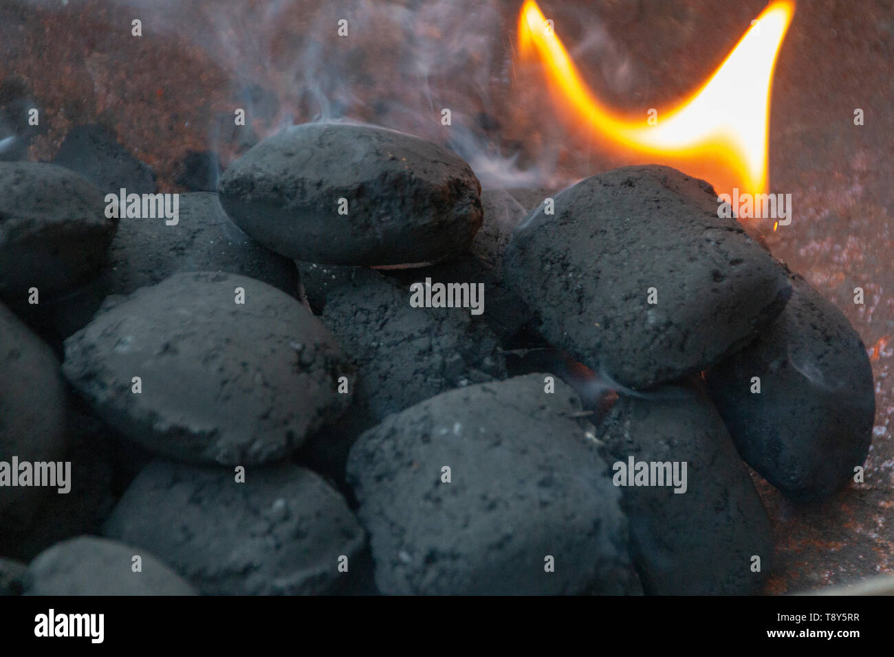 Eine Nahaufnahme von Rauch und schwarze Kohlen, wo die Flammen obwohl Emporragen Stockfoto