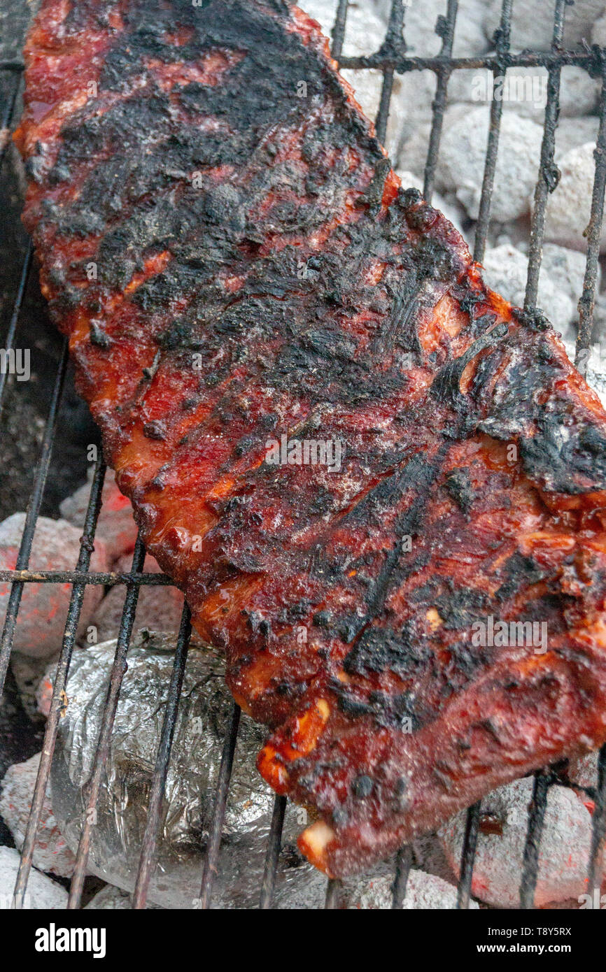 Eine Nahaufnahme von einem Rack von Rippen Kochen auf offenem Feuer Stockfoto