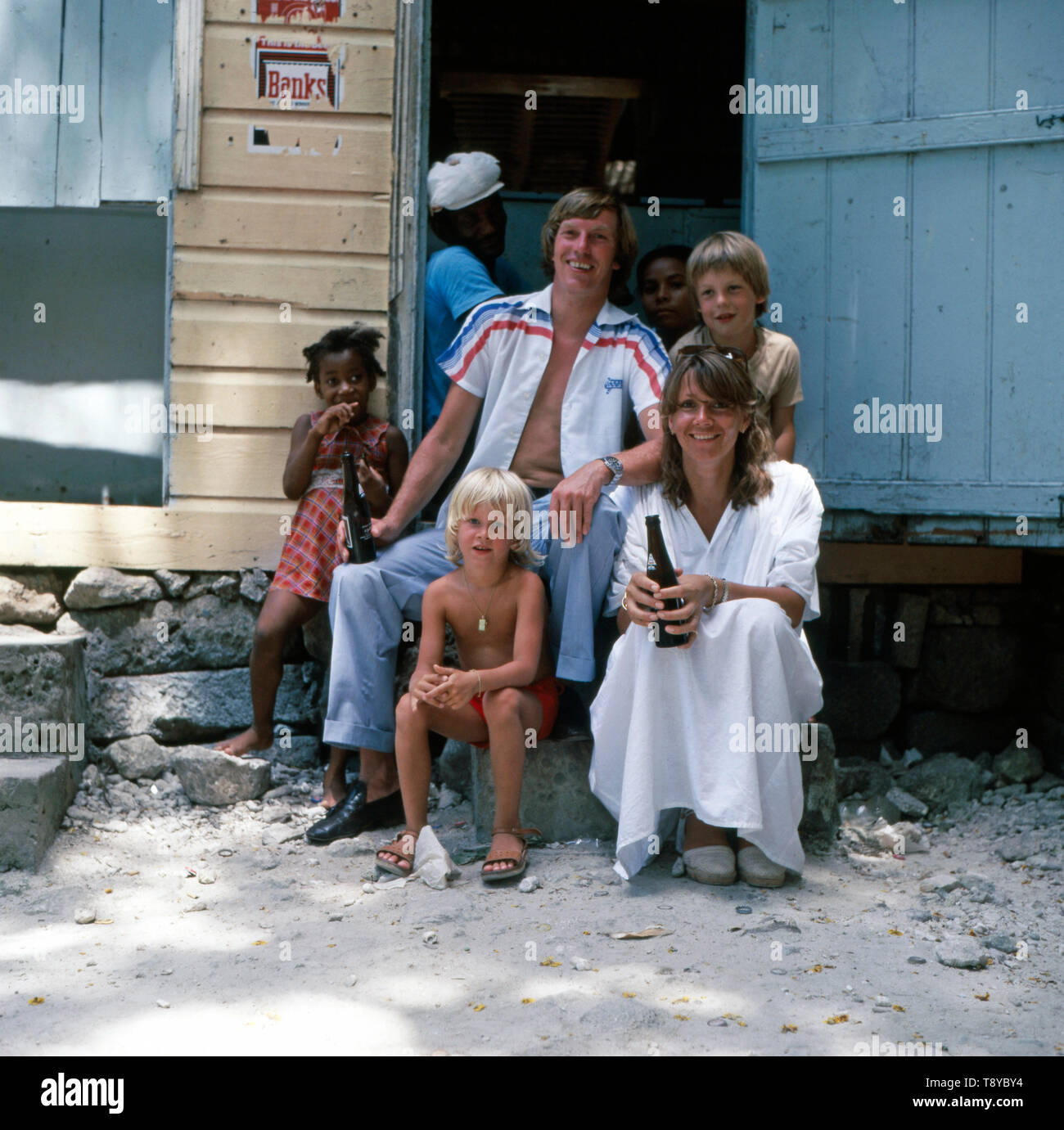 Der Rennfahrer und Prinz von Bayern Leopold posiert gemeinsam mit seiner Familie und einigen Einheimischen wahrscheinlich wähend der 1980er Jahre in den Bahamas für ein Foto vor dem Eingang zu einem Lokal. Der Rennfahrer und Prinz Leopold von Bayern mit seiner Familie und einigen Einheimischen wahrscheinlich während der 1980er Jahre in den Bahamas für ein Foto vor dem Eingang zu einem lokalen. Stockfoto