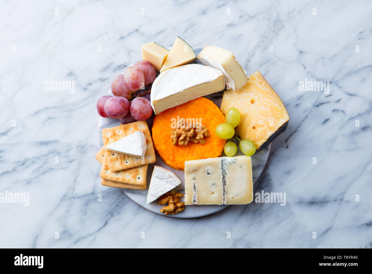 Auswahl an Käse, Trauben und Cracker. Marmor Hintergrund. Ansicht von oben. Kopieren Sie Platz. Stockfoto