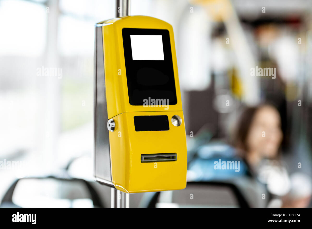 Gelbe Fahrkartenautomaten in der modernen Tram mit weiblichen Passagier auf dem Hintergrund Stockfoto