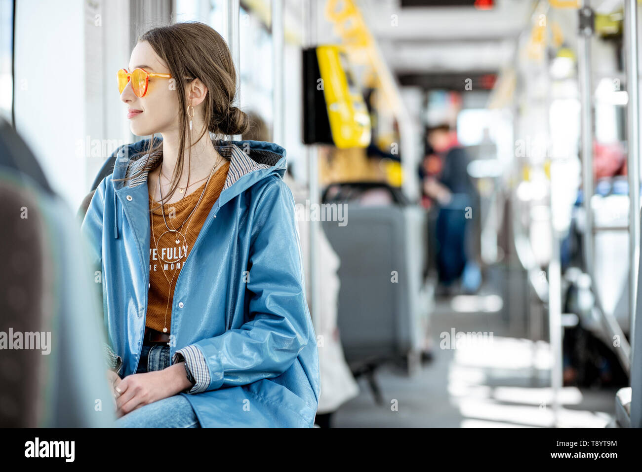 Junge stilvolle Frau gekleidet Hell genießen Urlaub im öffentlichen Verkehr, in der modernen Straßenbahn sitzen Stockfoto