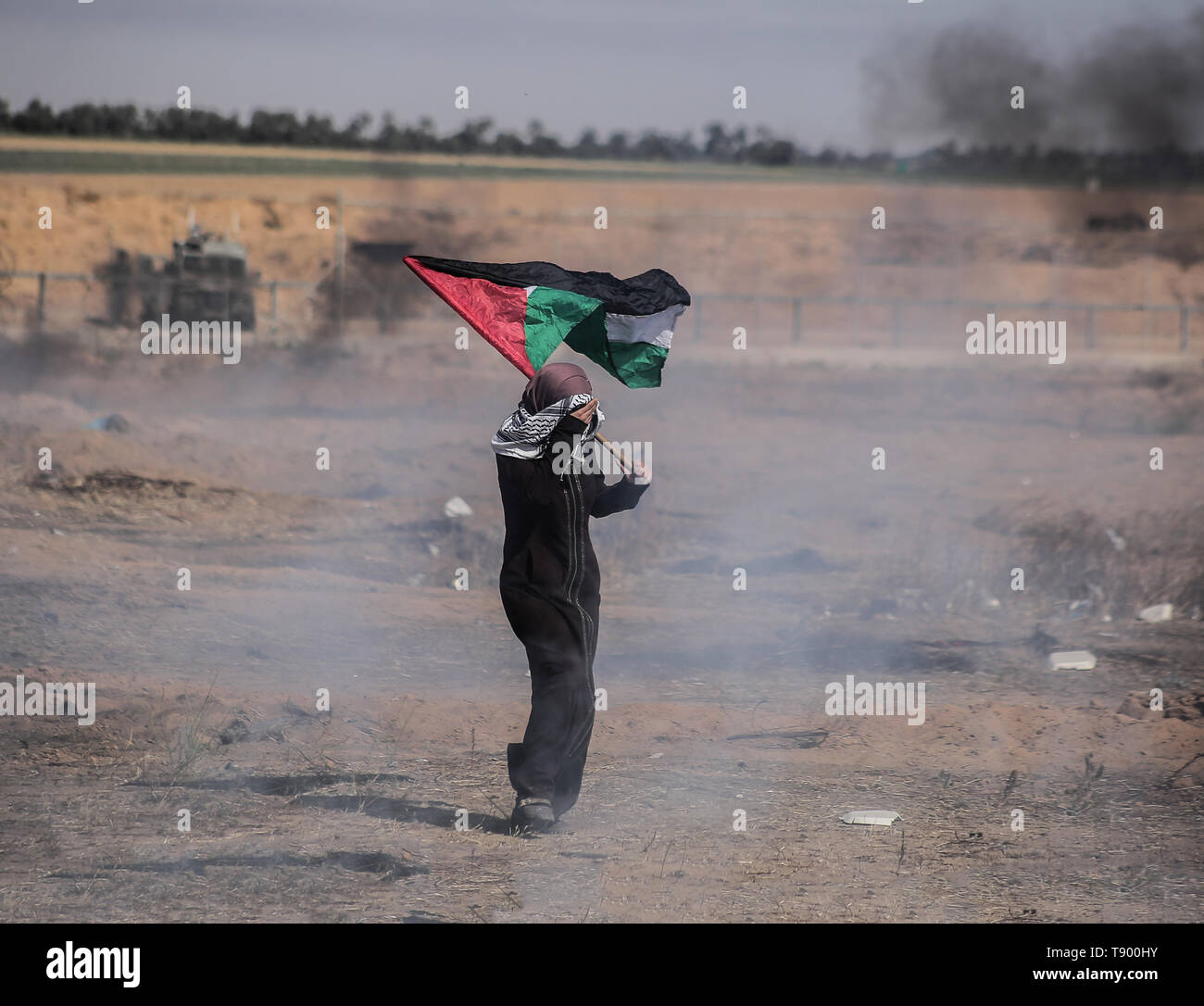 Eine palästinensische Demonstranten gesehen, die eine Flagge während der Auseinandersetzungen. Palästinenser mit israelischer Truppen während der 71-jährigen zusammengestossen - alte Nakba Tag Demonstration, für ein Ende der israelischen Blockade des Gazastreifens und das Recht auf ihre Wohnungen am Grenzzaun zwischen Israel und Gaza im südlichen Gazastreifen zurück. Stockfoto
