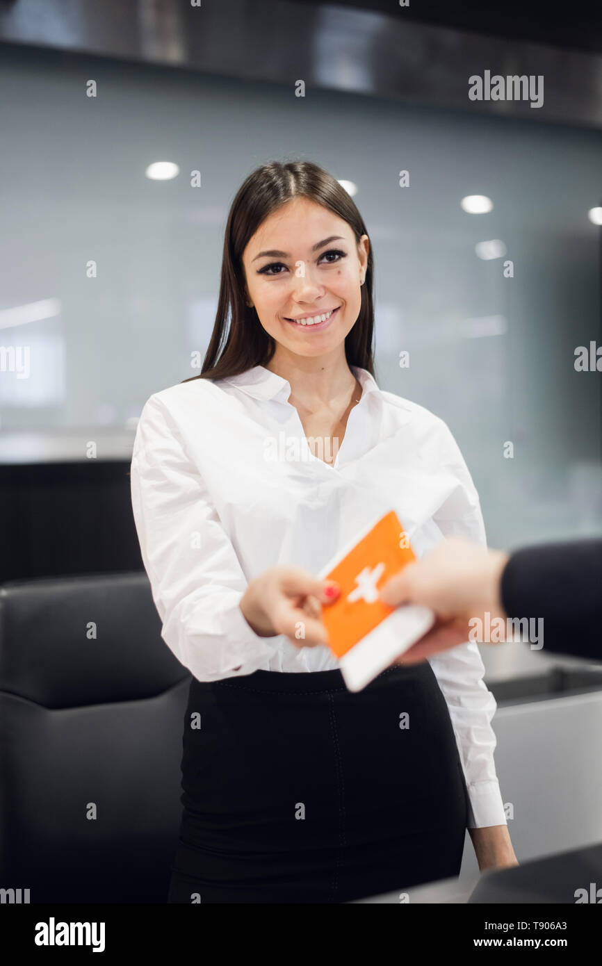 Freundliche Frau personal Pass von der Passagier am Flughafen Check-in-Schalter Stockfoto