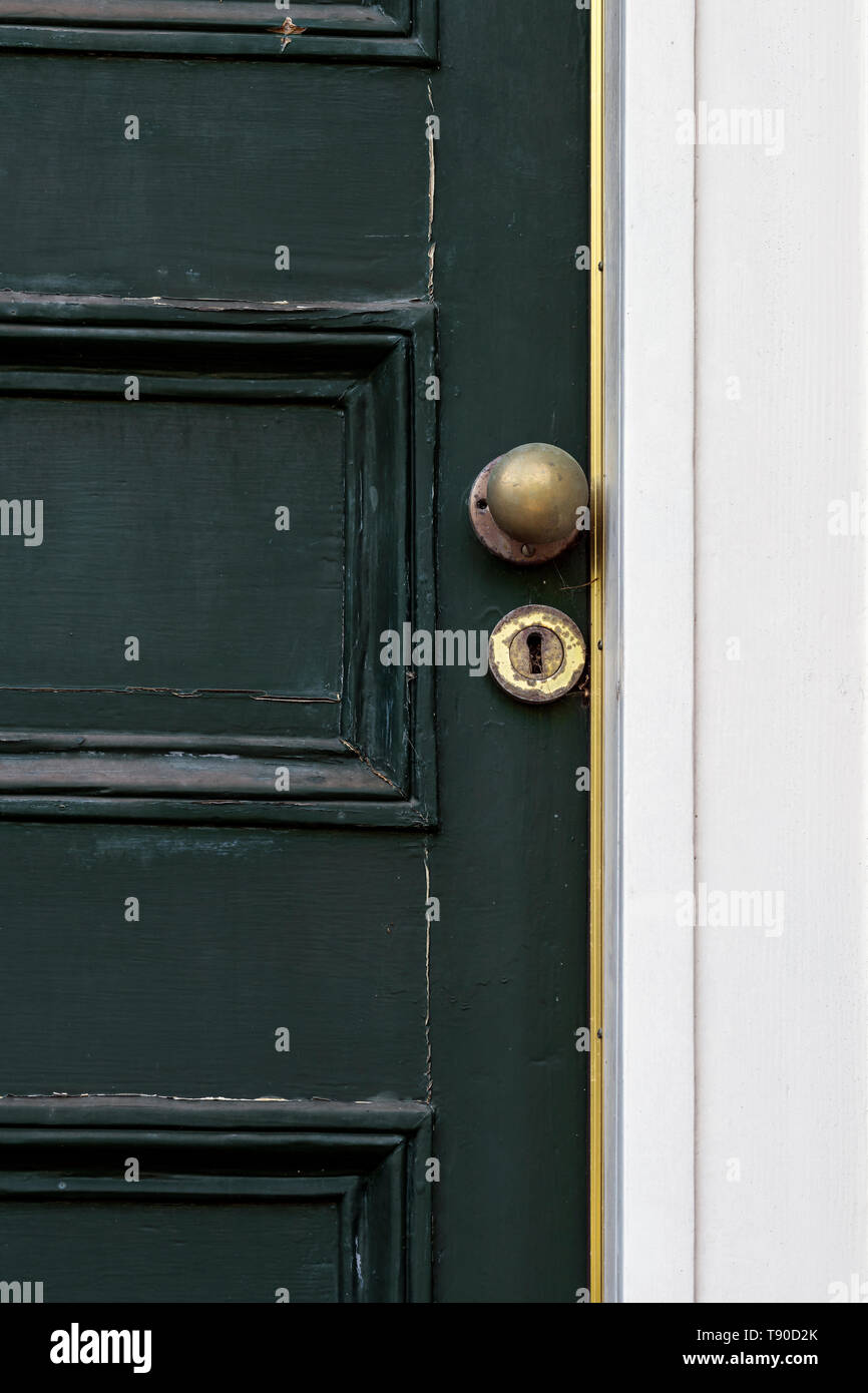 Alten grünen Haustür der viktorianischen Haus in desolaten Zustand mit abblätternde Farbe und getrübt Messing lion Klopfer, Letter Box, Knopf und Schlüsselloch. Stockfoto