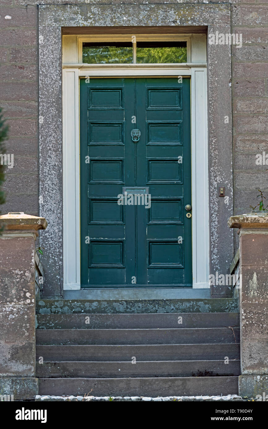 Alten grünen Haustür der viktorianischen Haus in desolaten Zustand mit abblätternde Farbe und getrübt Messing lion Klopfer, Letter Box, Knopf und Schlüsselloch. Stockfoto