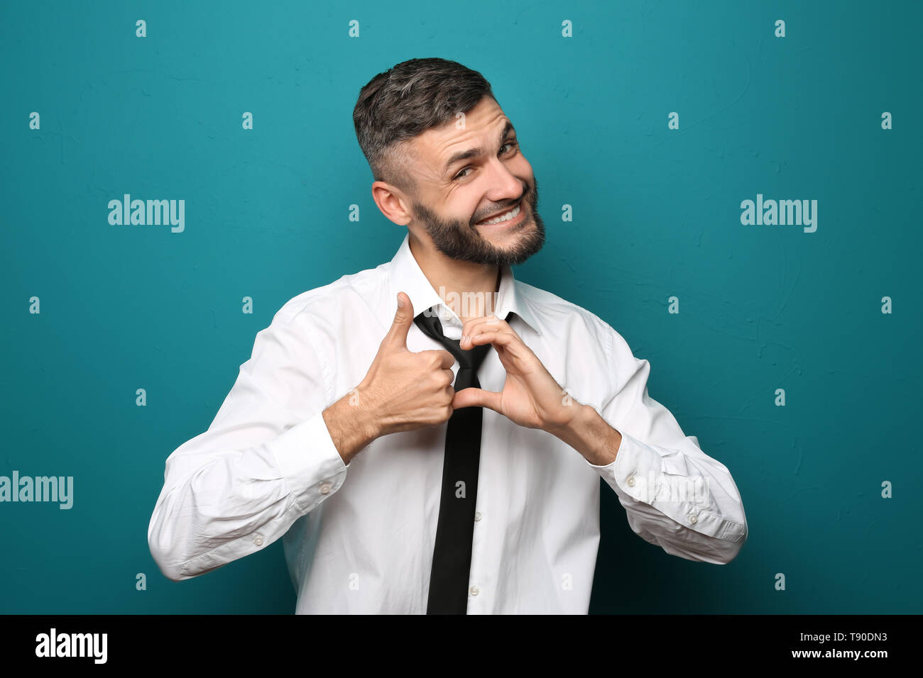Happy Geschäftsmann mit Daumen-nach-oben-Geste auf farbigen Hintergrund Stockfoto