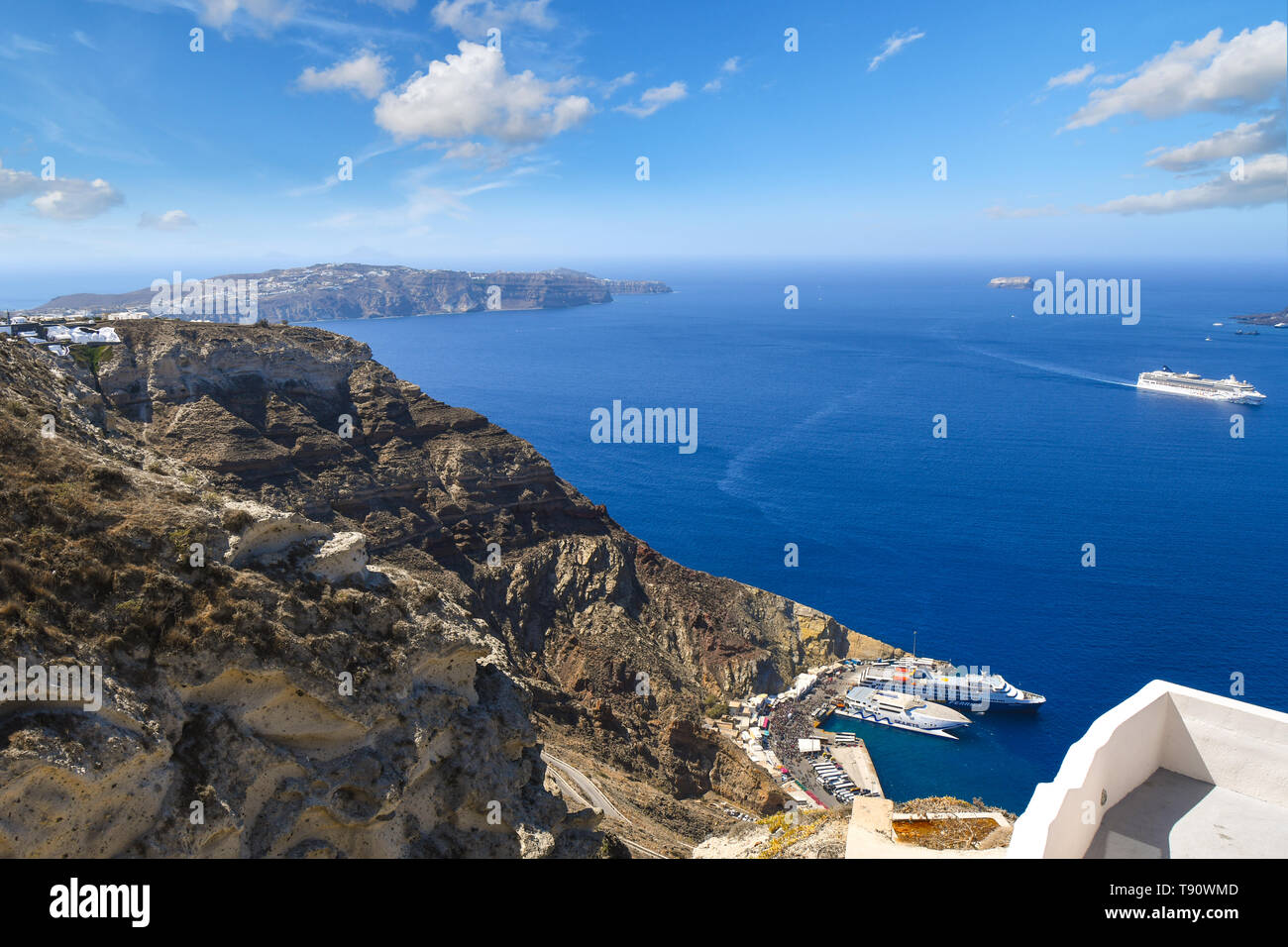 Aussicht von den Hügeln in der Nähe von Oia der Kreuzfahrt und Yacht Hafen und Schiffe auf See innerhalb der Caldera auf der Insel Santorini, Griechenland. Stockfoto