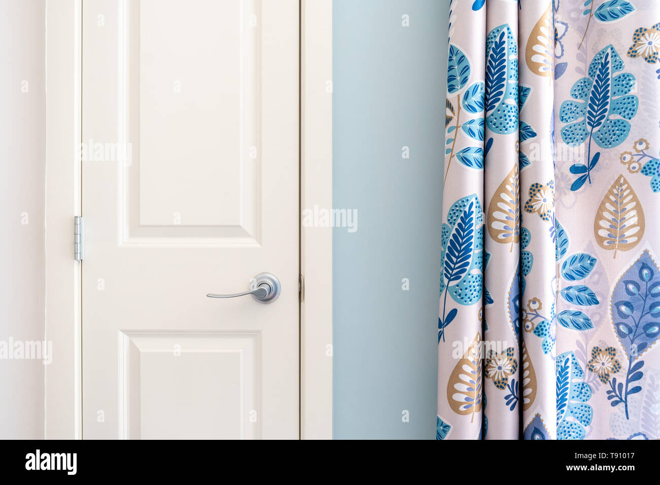Home Interior Übersicht kolonial Schrank Tür mit blauen Vorhang Dekor und hellen Blau gestrichene Wand. Stockfoto