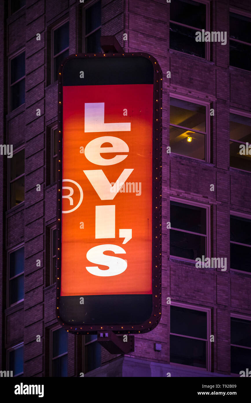 Beschilderung von Levi's Marke in New York City, USA in der Nacht auf eine Werbung board Glühen. Levi Strauss & Co. ist ein privat gehaltener American Clothing co Stockfoto