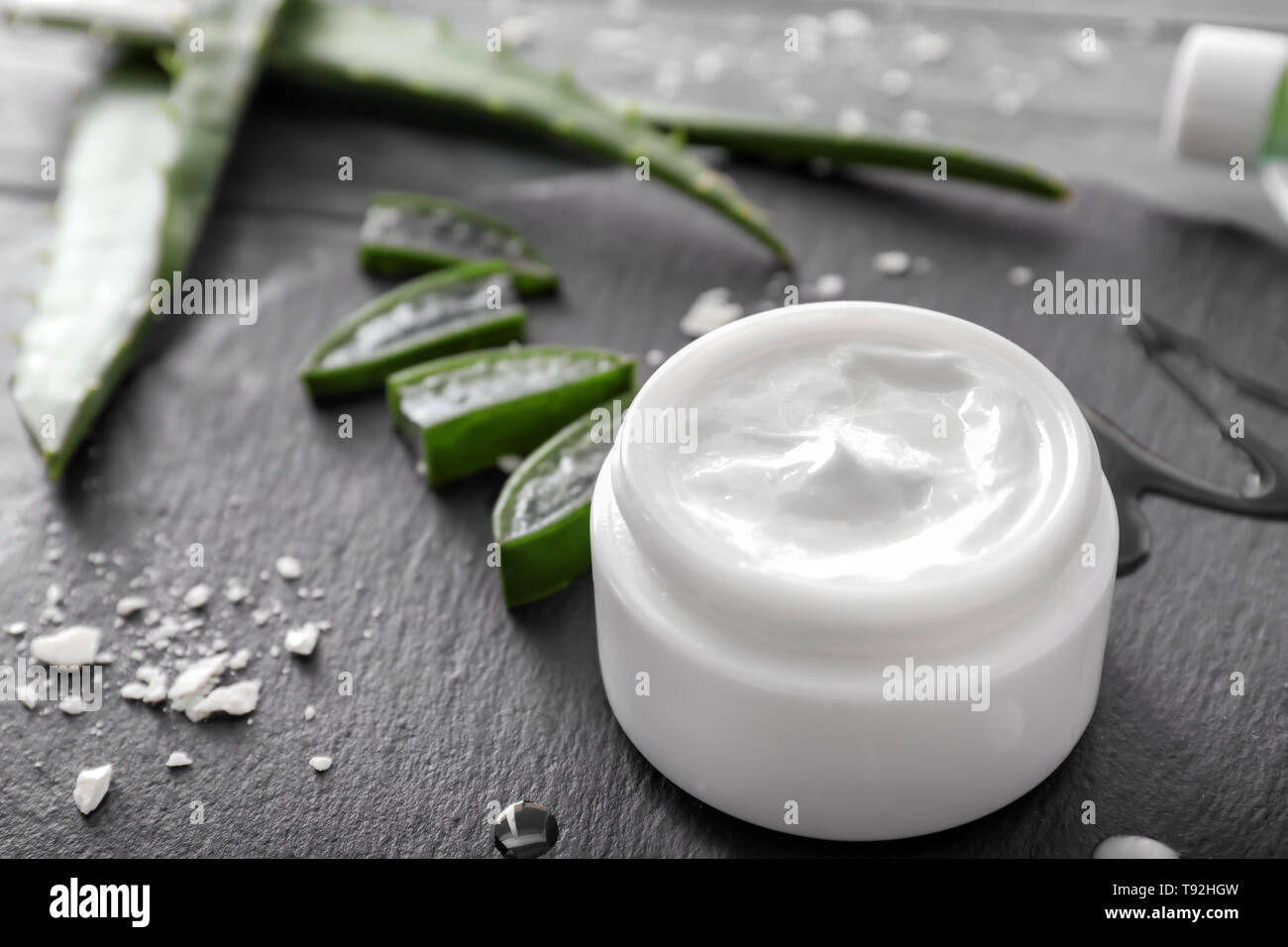 Glas mit Heilung Creme und Aloe auf schiefer Platte Stockfoto